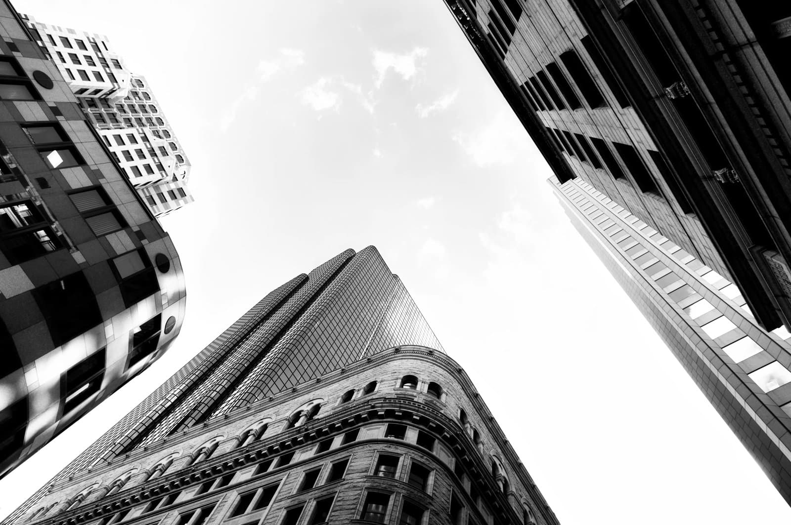 Upward view of tall city skyscrapers converging toward the sky