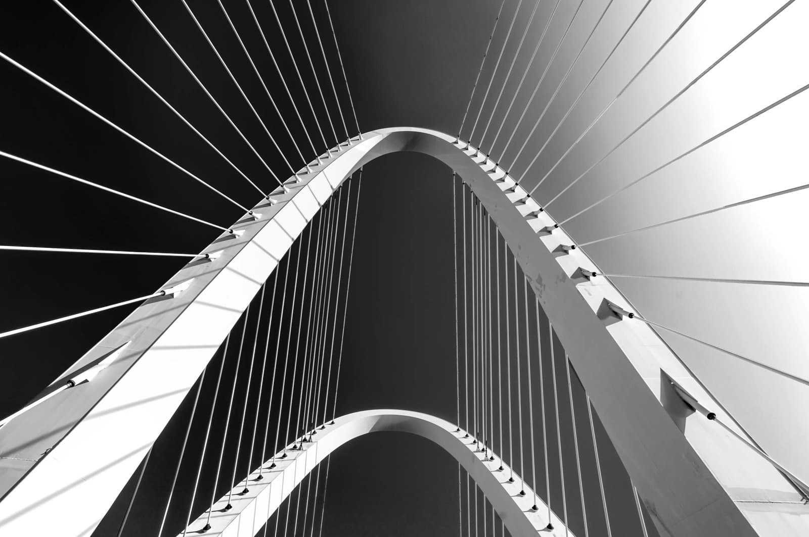 Cable-stayed bridge arches and suspension cables viewed from below