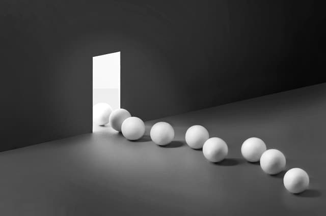 A row of sphere leaving through an opening to another brighter side