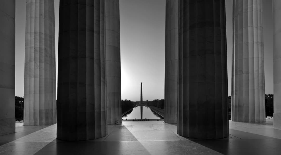 View of the Washington Monument framed between large stone columns.