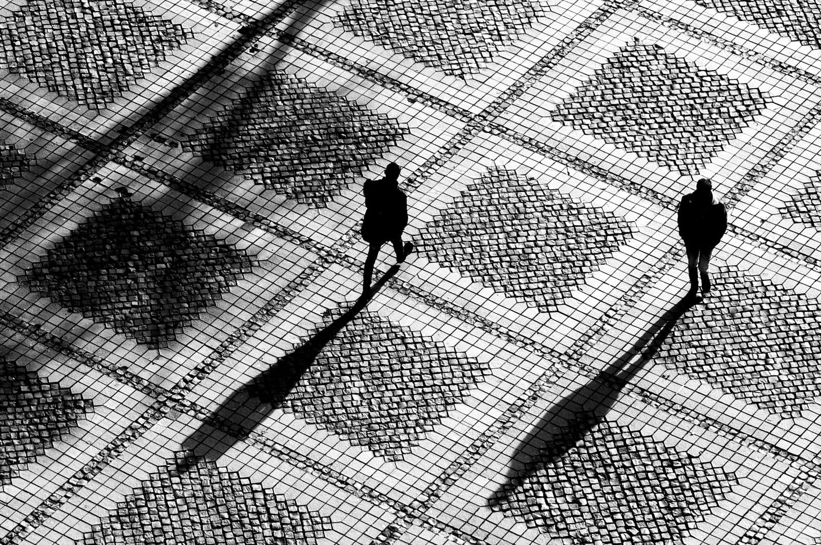 people walking across a cobbled square
